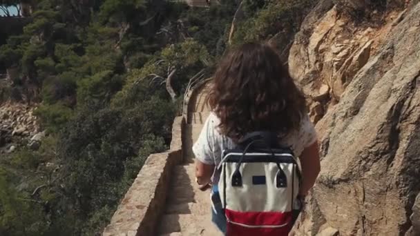 성인 여성이 국립 공원의 언덕 경사면에 있는 오래 된 돌 계단으로 하강 합니다. — 비디오