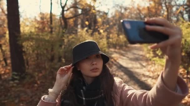 Chica encantadora tomando selfie en un bosque . — Vídeos de Stock