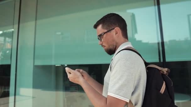 Ο αρσενικός τουρίστας περπατάει κοιτάζοντας την εμφάνιση του κινητού του τηλεφώνου — Αρχείο Βίντεο