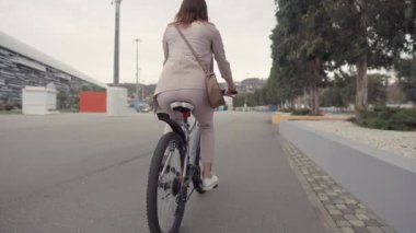 Genç ince kadın yaz gününde bir bisiklet sürme, arka görünüm