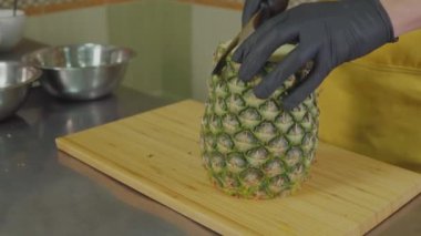 Erkek Şef mutfak, yakın çekim bir ananas soyuluyor