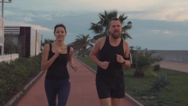 Par värmer upp jogging i parken. — Stockvideo