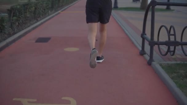 Running man buiten in de avond. — Stockvideo