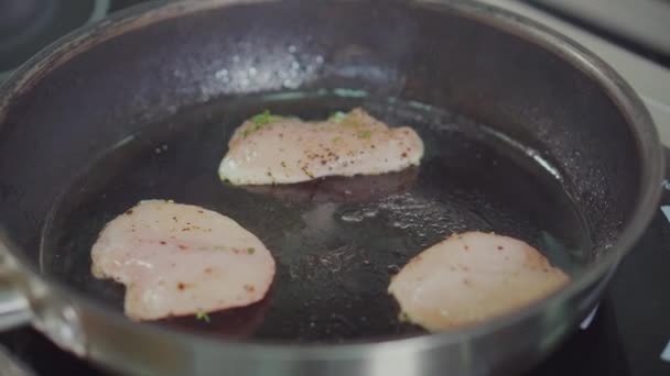 Chef está convirtiendo pedazos de pechugas de pollo, freír en la sartén, primer plano — Vídeos de Stock