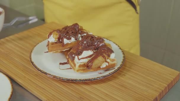 Pastry cook is decorated Belgian waffles by fresh blueberries, close-up — Stock Video