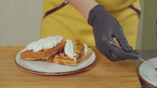 Gebak Cook zet gebakken bananen op Belgische wafels met slagroom — Stockvideo