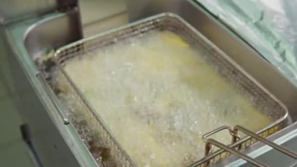 Master cook is deep-frying potatoes in kitchen of restaurant fast food — Stock Video