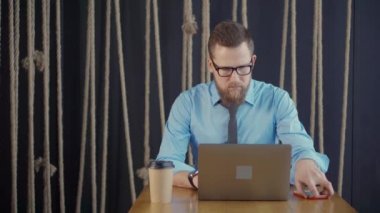 Kafede dizüstü bilgisayarı olan bir iş adamı..