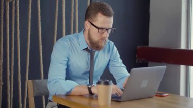 Ciddi adam laptop kafede çalışıyor.