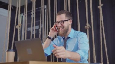 Bir dizüstü bilgisayar ile bir restoranda heyecanlı işadamı.