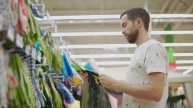 Erkek alışveriş hiperpazarda elinde koruyucu kauçuk eldiven hissediyor