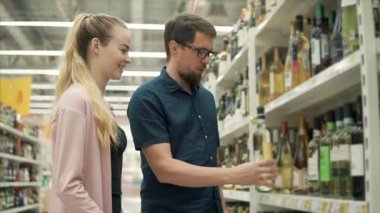 Genç çift süpermarket bir bölümde şarap tartışmak