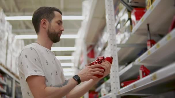 Driver man håller ett pneumatiskt lyft Jack i handen i en butik för automobilister — Stockvideo