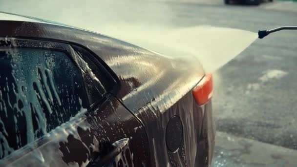 Het water stroomt op auto lichaam tijdens het wassen, schoonmakend schuim, close-up mening — Stockvideo