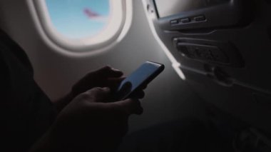 Uçan uçağın bir kabin telefon ekranında yazarak erkek elleri yakın yukarı görünümü