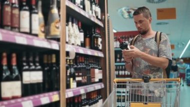 Yetişkin adam dükkanda şarap seçimi.