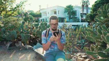 Adam bir telefon ile Bench dışarı asılı.