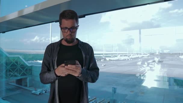 Mann mit Smartphone allein am Flughafen. — Stockvideo