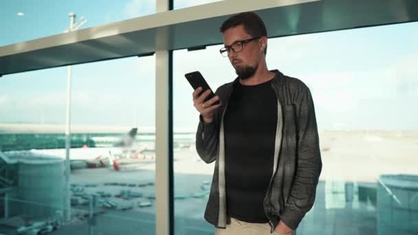 Junger Mann benutzte Handy am Flughafen. — Stockvideo