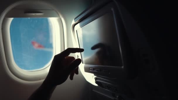 Passagier raakt sensor scherm in de cabine van het vliegtuig tijdens de vlucht, close-up — Stockvideo