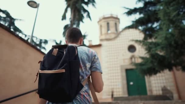 Mann steigt an Sommertag auf uralte Treppe an Straße zu altem Gebäude — Stockvideo