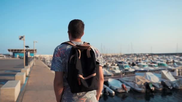 Alone man is een wandeling langs ligplaats met kleine prive-jachten in het zonnige dag — Stockvideo