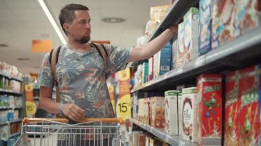 Blanes, Ispanya-Eylül, 2018: tek adam raf bir mağazada Mısır gevreği ile kutu alıyor