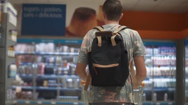 Чоловіча покупець збирається в області продажу в супермаркеті, перегляд назад — стокове відео
