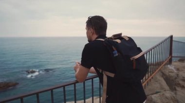 Hüzünlü yetişkin adam rock akşam geceleri okyanus görünümünde yalnız izliyor