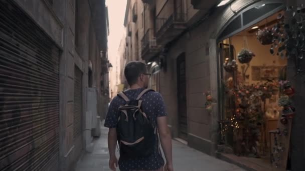 Turista masculino solitário está passeando na rua velha, olhando na loja de lembranças — Vídeo de Stock