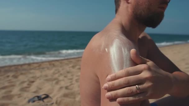 Man zetten zon lotion op het lichaam. — Stockvideo