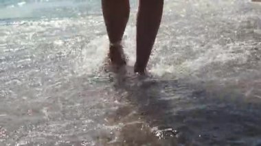 Sandalet kadın ayaklar kum ve çakıl ile plaj üzerinde adım, yakın-up