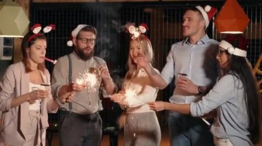 Genç neşeli erkek ve kadınlar Noel tatilinde Bengal yangınları yanıyor