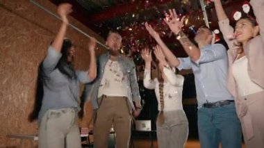 Mutlu genç insanlar dans ve Noel gece partisinde simler atma