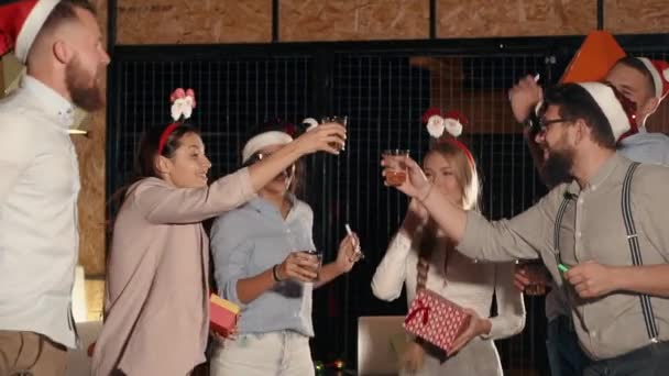 Компания молодых друзей празднуют Рождество, нажимая стакан с алкоголем — стоковое видео