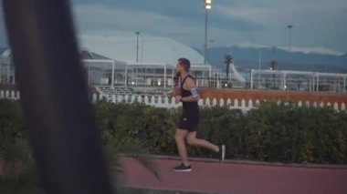 Sportsman geceleri dağlarda görünümü ile şehirde yalnız çalışıyor