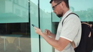 Yürürken akıllı telefon tutan adam.