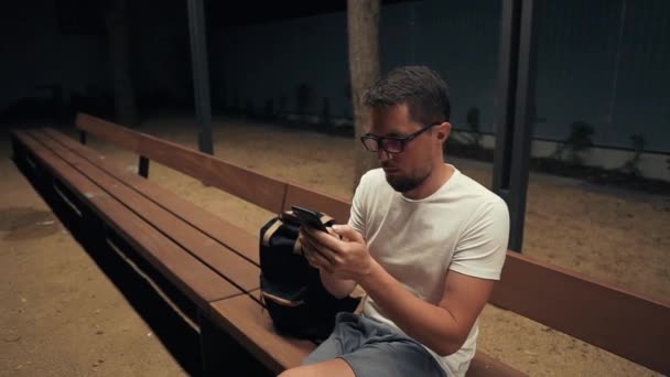 Mann abends allein mit Smartphone. — Stockvideo