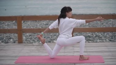 Yoga Eğitmen kadın Seacoast üzerinde egzersizleri yapıyor
