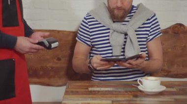 Sakallı müşteri cüzdanından kart alarak, kafede fatura görüntüleme ve ödeme