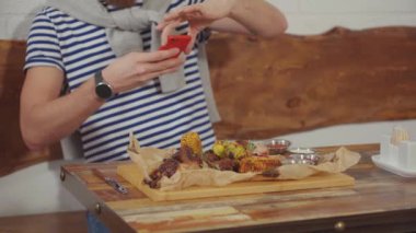 Adam restoranda akıllı telefon tarafından onun yemek fotoğrafını, yakın çekim