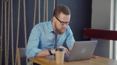 Neşeli adam Notebook ekranında bakıyor ve mobil çağrı cevap