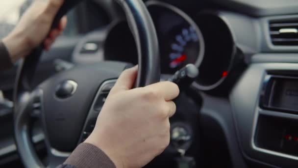 男性の手は、現代の自動車のステアリングホイールを回している, クローズアップビュー — ストック動画