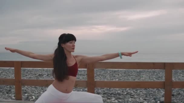 Femme est en train de changer la position de yoga asanas sur la classe en plein air près de la mer — Video