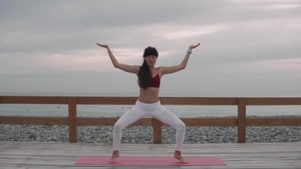 Bruna donna sta eseguendo posa tradizionale di hatha yoga all'aperto durante il giorno — Video Stock