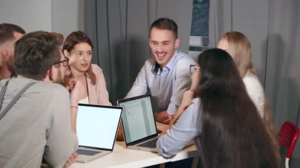 Група молодих фахівців з маркетингу весело зустрічаються в офісі — стокове відео