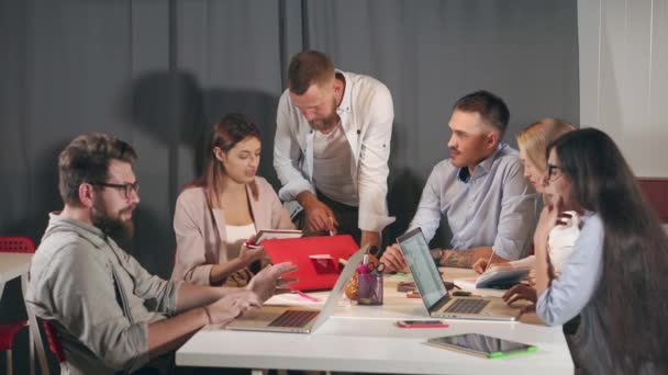 Los especialistas están discutiendo ideas e informes en reuniones de negocios en empresas jóvenes — Vídeo de stock