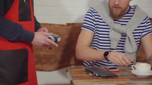 Cliente masculino está tomando café e pagando para garçom por smartphone com NFC — Vídeo de Stock