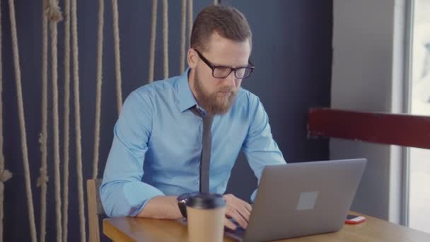 Ο άνθρωπος εργάζεται σε σύγχρονο δωμάτιο γραφείου, πληκτρολογώντας το laptop τη χειμερινή ημέρα — Αρχείο Βίντεο