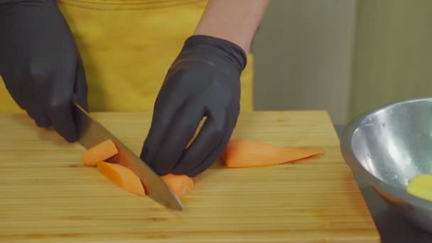 Hände des Kochs schneiden Karotten. — Stockvideo